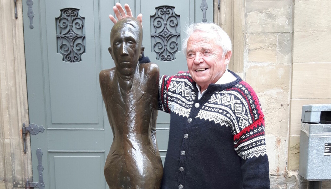 Stefan Stippl med lusekofte i byen Schwäbisch Hall. Her står han sammen med skulpturen Mann im November.