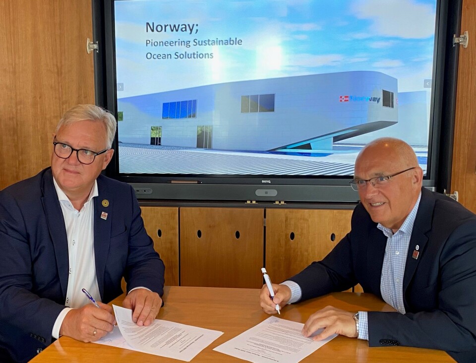 Ole Johan Sandvær i Innovasjon Norge er generalkommissær for Norway Expo 2020 Dubai og Paul Birger Torgnes, styreleder i Campus BLÅ Norsk Havbrukssenter AS, signerer partneravtalen mellom de de to. Foto: Campus BLÅ Norsk Havbrukssenter AS
