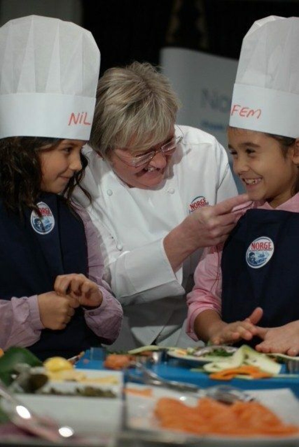 Fiskeriminister Elisabeth Aspaker lager norsk laks sammen med tyrkiske barn. Foto: FKD