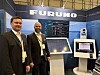 To menn står foran en Furuno-messestand med skjermer og demonstrasjonsutstyr.