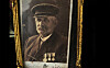 Innrammet, sepiafarget portrett av en mustasjekledd mann i uniform med medaljer.