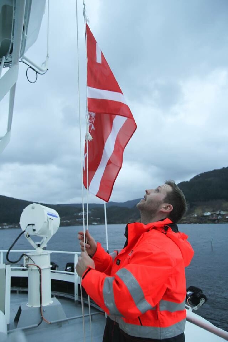 Kaptein Erling Lorentzen fra NFT heiser rederiflagget etter overleveringen. Foto: Havyard Group AS
