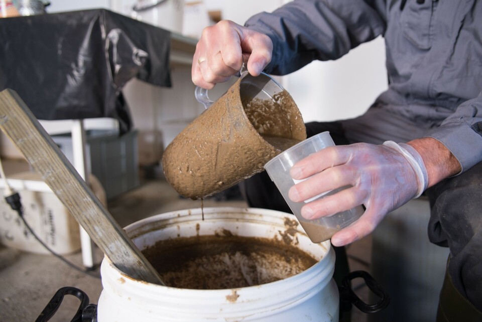 Forsker Joshua Fenton Cabell stikker et litermål ned i en stor bøtte med flytende brun masse. Langsomt heller han det over i små plastglass. Det er den ferskeste leveransen med fiskeslam til forskningsstasjonen til Norsk institutt for bioøkonomi (NIBIO) på Tingvoll i Møre og Romsdal.Foto: Anette Tjomsland/NIBIO.