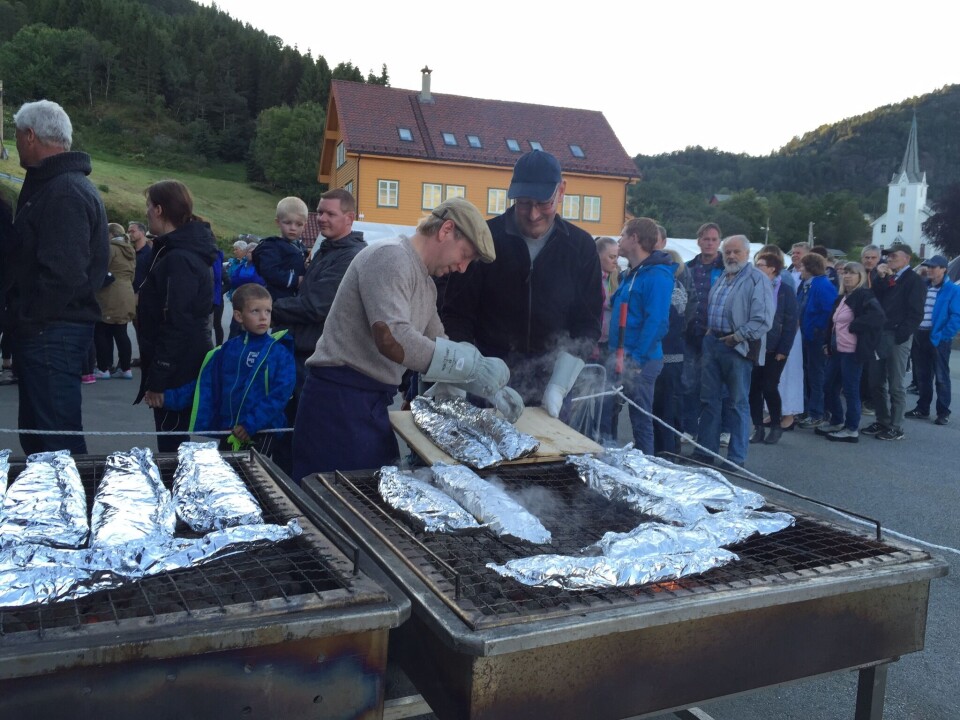 Lang, lang rekke for å sikra seg godsaker. Grillsjefane Oddvar Helland og Åge Enes i sving for Alsaker i fjor. Foto: Alsaker.