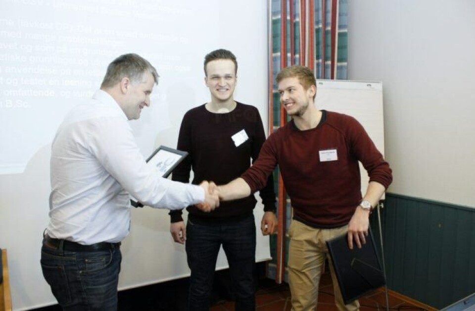 Juryleder Rune Volden fra Ulstein Power & Control deler ut prisen til NTNU-studentene Sveinung Liavaag og Albert Havnegjerde. Vegard Kamsvåg var ikke tilstede. Foto: NFA
