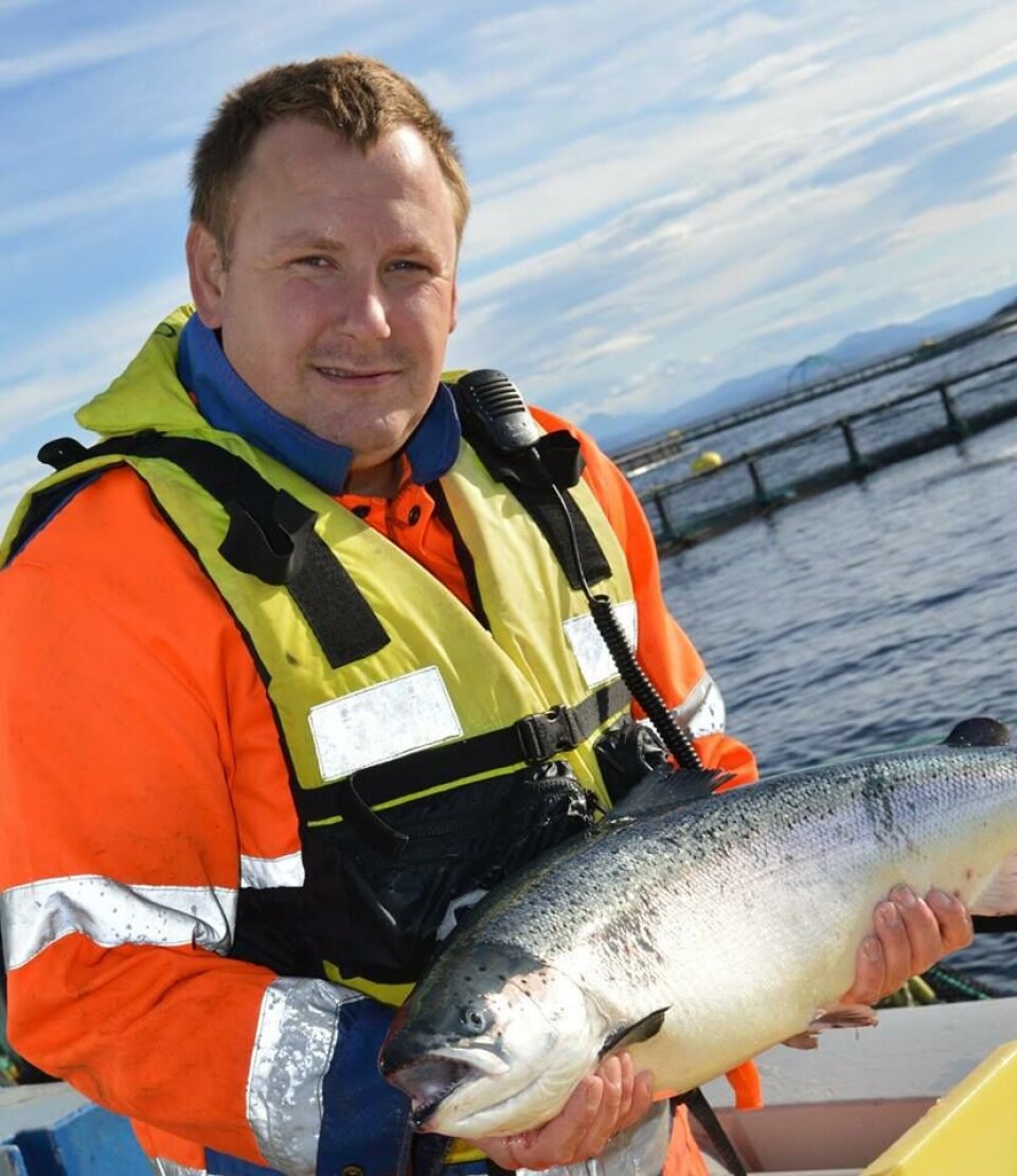 Lokalitetsleder Arve Mohn Haug har aldri angret på at han takket ja til tilbudet om jobb på sjøen. Her er han avbildet med en flott laks på merdkanten. Foto: Emilsen Fisk