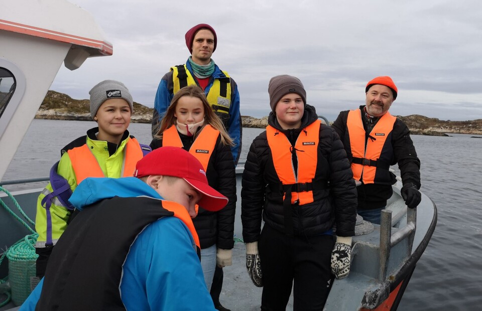 Her ankommer de heldige vinnerne av en innovasjonscamp, SalmoNor sin lokalitet «Lille Kvitholmen». På bildet er vinnerne i tillegg til Bjørn-Magne Anfinnes (driftstekniker) og læreren fra Terråk Skole. Foto: Ole Andreas Drønen/Kyst.no.
