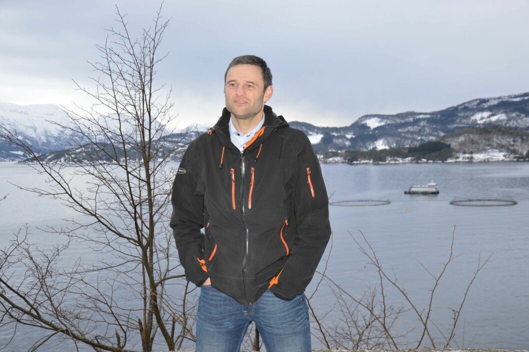 Erlend Haugarvoll, daglig leder i Lingalaks. Bak han kan man se fôrflåten «Aud», i Saltkjelen, der fisken har blitt fôret på marine algeoljer siden oktober 2018.  Foto: Ole Andreas Drønen