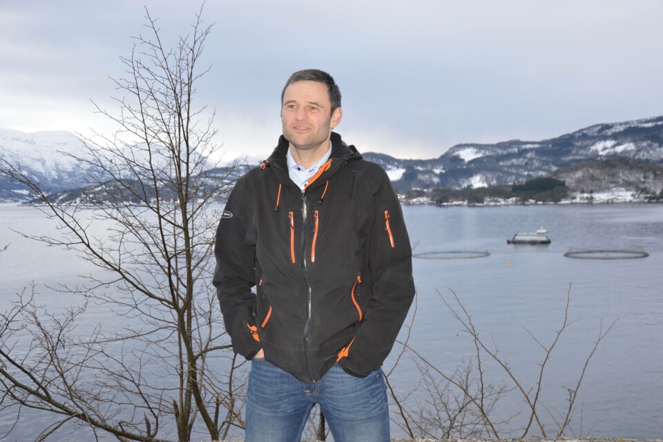 Erlend Haugarvoll, daglig leder i Lingalaks. Bak han kan man se fôrflåten «Aud», i Saltkjelen, der fisken har blitt fôret på marine algeoljer siden oktober 2018. Foto: Ole Andreas Drønen